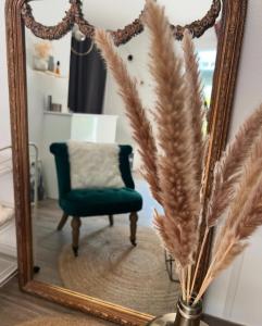 a mirror and a chair in a room with a chair and feathers at Beautiful Cocoon in Neuchâtel