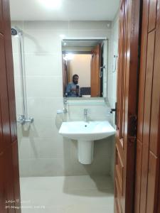 a man taking a picture of a bathroom with a sink at Islamabad Crest Villas in Islamabad