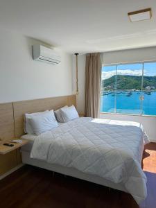 a bedroom with a large bed with a large window at Pousada Atalaia Boutique FR in Arraial do Cabo +180 photos
