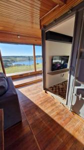 ein Wohnzimmer mit einem Kamin und Blick auf das Wasser in der Unterkunft Refúgio Serra Lebre: Cabana Luxo Panorâmica em 6 Hectares de Araucárias in São Francisco de Paula
