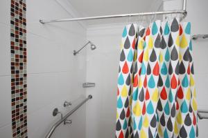 a bathroom with a shower curtain with colorful dots at Acacia Snowy Motel in Jindabyne +37 photos