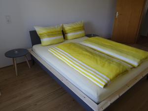 a bed with yellow sheets and yellow pillows at Ferienwohnung Mit Garten Im Schönen Tannheim in Tannheim