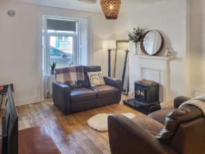 a living room with a couch and a chair and a stove at Wolfe Tone Apartment in Sligo