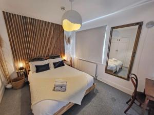 a bedroom with a large bed and a mirror at Wolfe Tone Apartment in Sligo
