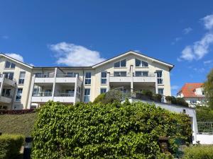 a large white building with bushes in front of it at Apprtementhaus Victoria - WE B 06 - Stranddüne in Sassnitz