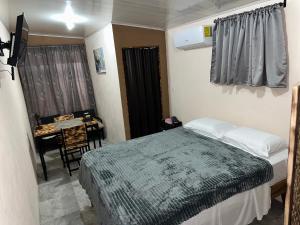 a bedroom with a bed and a table and a desk at Campos del Mariachi in Fortuna