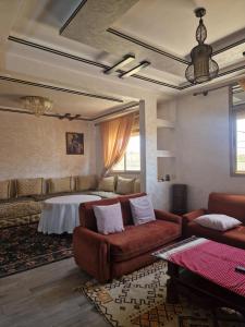 a living room with a couch and a table at MountainHouse- cozy and spacious family triplex in Midelt