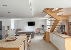 a kitchen and living room with a loft at La Cidrerie, havre entre campagne et océan in Plouhinec