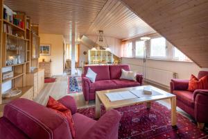 a living room with purple couches and a table at Haus Ahorn Ferienwohnung in Bad Dürrheim