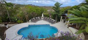 格罗斯岛Cap Pavilion, St Lucia 6 bed luxury villa, private pool, gardens and 360' sea views的花园里的游泳池，旁边有楼梯