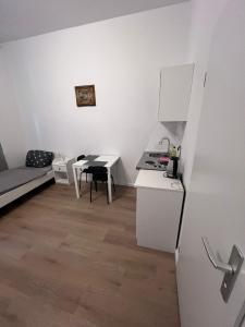 柏林Lovely apartment in Berlin4的白色的小厨房配有桌子和冰箱 更多3张照片