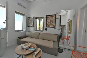 a living room with a couch and a table at Kariki Blue Triantaros-Tinos in Triandáros