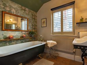 a bathroom with a tub and a sink and a mirror at 5 Bed in Dunster 63301 in Dunster +44 photos