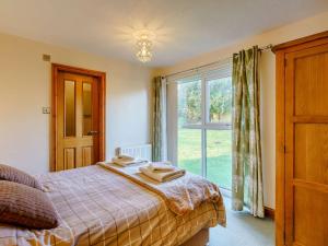 a bedroom with a bed and a large window at 4 Bed in Duddon Valley 89418 in Ulpha
