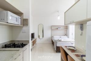 a white kitchen with a bed in a room at Lindo Estúdio em Floripa EVA0506 in Florianópolis