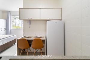 a small kitchen with two chairs and a refrigerator at Lindo Estúdio em Floripa EVA0506 in Florianópolis