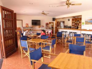 two people sitting at tables in a restaurant at Hostal Sa Prensa in Ciutadella