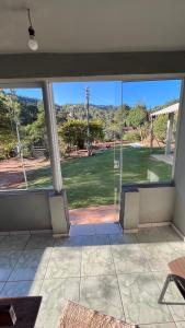 a large window in a room with a view of a yard at Casa da Wal in Camanducaia
