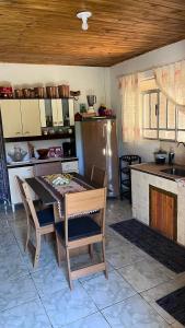 a kitchen with a table and chairs in a kitchen at Casa da Wal in Camanducaia +8 photos