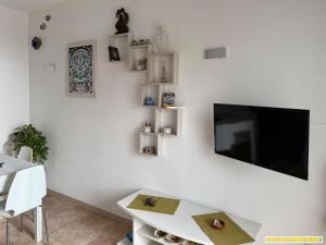 Una sala de estar con un televisor en una pared blanca. en Isola delle Femmine Holiday, en Isola delle Femmine 13 fotos más