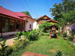 ein Haus mit einem Garten und einer Statue im Hof in der Unterkunft Pensiunea Speranța in Pleşcoi