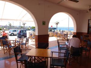 a man sitting at a table in a restaurant at Hostal Sa Prensa in Ciutadella