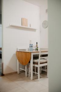 a white table with a chair and a table with a bowl at Platz Apartman in Văleni