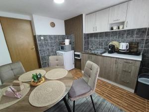a kitchen with a table and chairs in a room at Apartman 4A in Bihać
