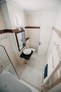 a bathroom with a sink and a mirror and a toilet at Platz Apartman in Văleni