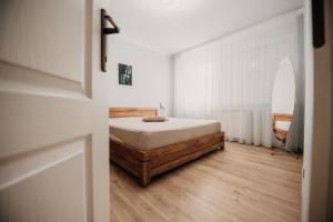 a bedroom with a bed and a surfboard on the wall at Platz Apartman in Văleni