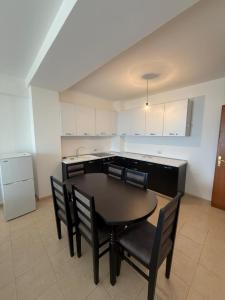 a kitchen with a table and chairs in a room at 9apartaments shengjin in Lezhë +7 photos