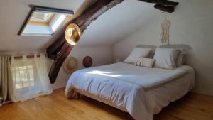 a bedroom with a large bed in a attic at Gîte et chambres d'hôtes Aux Charlots in Lagarde-Hachan