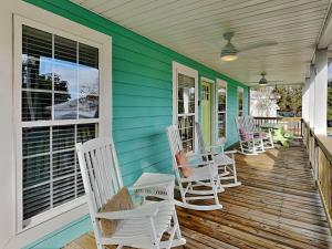 タイビーアイランドにあるBack River Bungalowの白いロッキングチェア付きポーチ