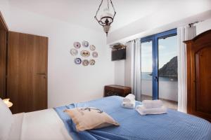 una camera con letto blu e vista sull'oceano di Villa Elias a Archangelos