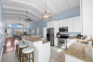 a large kitchen with white cabinets and bar stools at Channel Vibes in Myrtle Beach