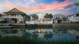 a group of houses on the water at sunset at Channel Vibes in Myrtle Beach