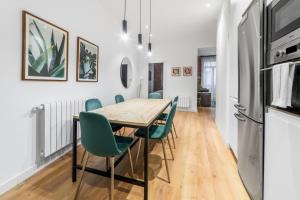 jadalnia z drewnianym stołem i zielonymi krzesłami w obiekcie 2 bedrooms 1 bathroom furnished - Centro - equipped & stylish - Minty Stay w Madrycie