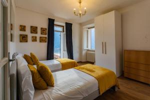 a bedroom with two beds and a chandelier at Villetta Panebianco Home in Castagna 11 by Rent All Como in Nesso