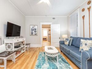 a living room with a blue couch and a tv at Sea View 3 in Tybee Island