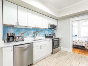 a kitchen with white cabinets and stainless steel appliances at Sea View 3 in Tybee Island