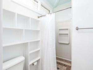 a bathroom with white shelves and a shower at Sea View 3 in Tybee Island +23 photos