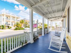 a porch with a white chair on a house at Sea View 3 in Tybee Island