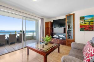 a living room with a view of the ocean at Sea Spray B306 in Bloubergstrand