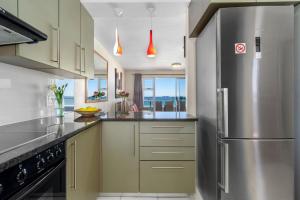 a large kitchen with a stainless steel refrigerator at Sea Spray B306 in Bloubergstrand