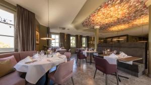 een eetkamer met witte tafels en stoelen bij Castell Hotel & Restaurant in Leinsweiler
