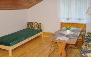 a room with a bed and a table and a couch at Cozy Home In Biskupice With Wifi in Biskupice
