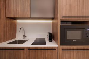 a kitchen with a sink and a microwave at Kampana Corfu in luxury in Corfu