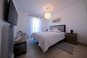 a bedroom with a bed and a flat screen tv at Magnifique T3 proche de la plage in Calvi