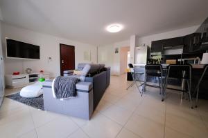 a large living room with a couch and a kitchen at Magnifique T3 proche de la plage in Calvi +1 photo