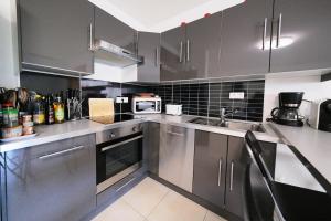 a kitchen with stainless steel cabinets and a sink at Magnifique T3 proche de la plage in Calvi